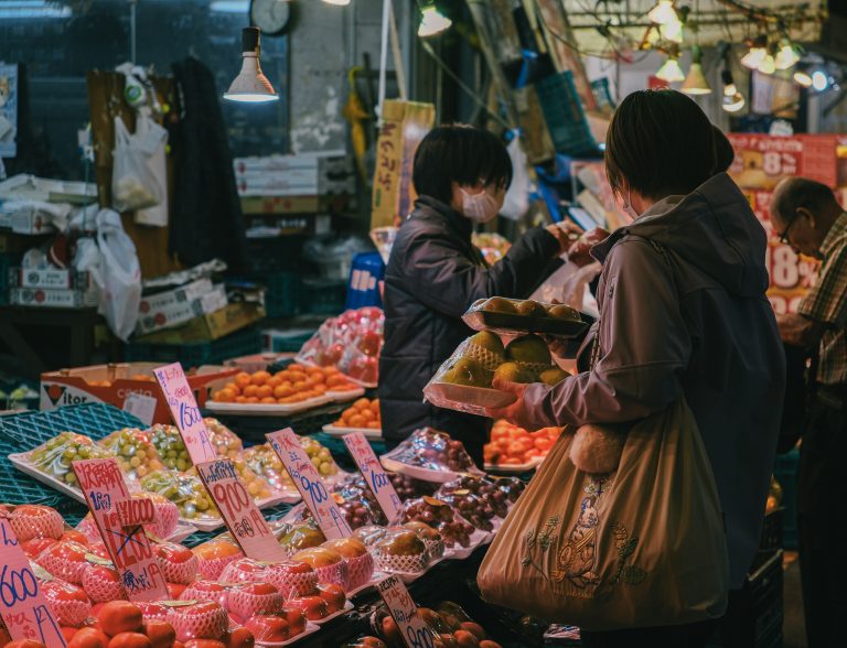 People shopping at a vibrant outdoor fruit market.